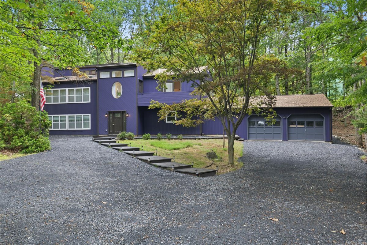 Wales House surrounded by mature trees and its expansive gravel driveway