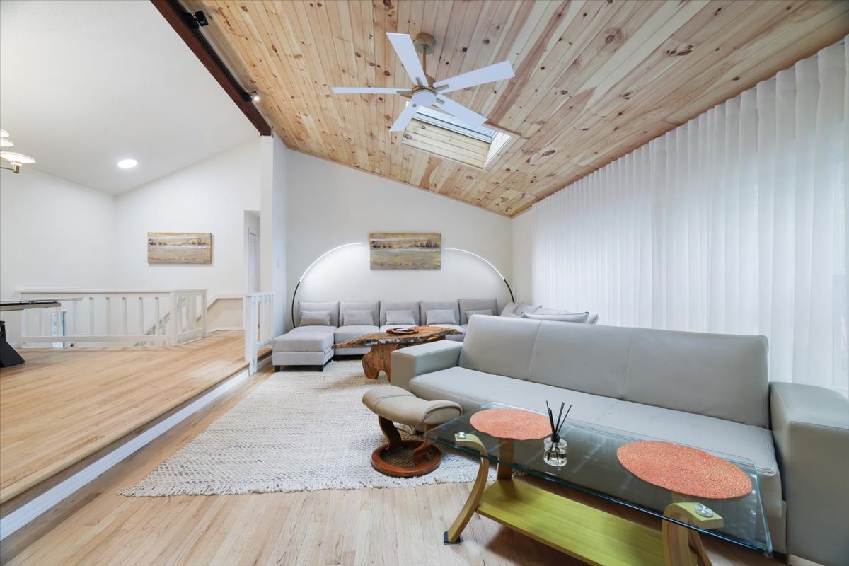 Spacious vaulted living room with wood ceiling and comfortable seating